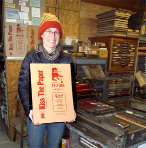 Film maker
                  Fiona Owtway with her new posters at the Vandercook
                  they were printed on.